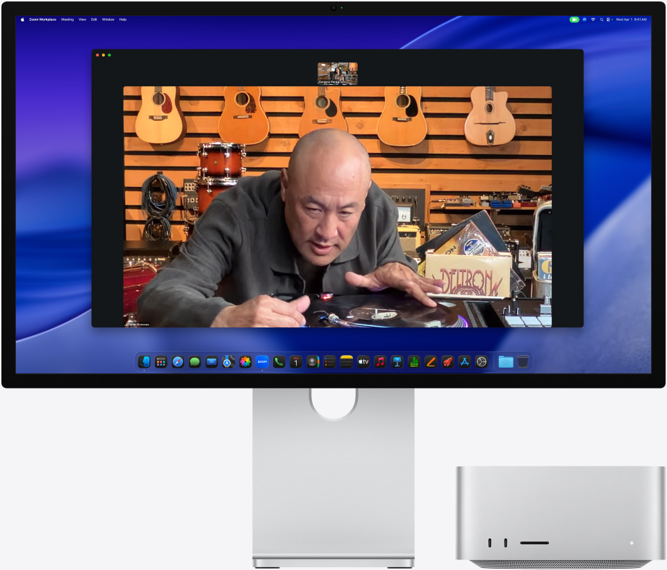 Tijekom videopoziva na zaslonu Studio Display XDR s Mac Studiom smještenim ispod, osoba u glazbenoj trgovini izbliza promatra gramofon