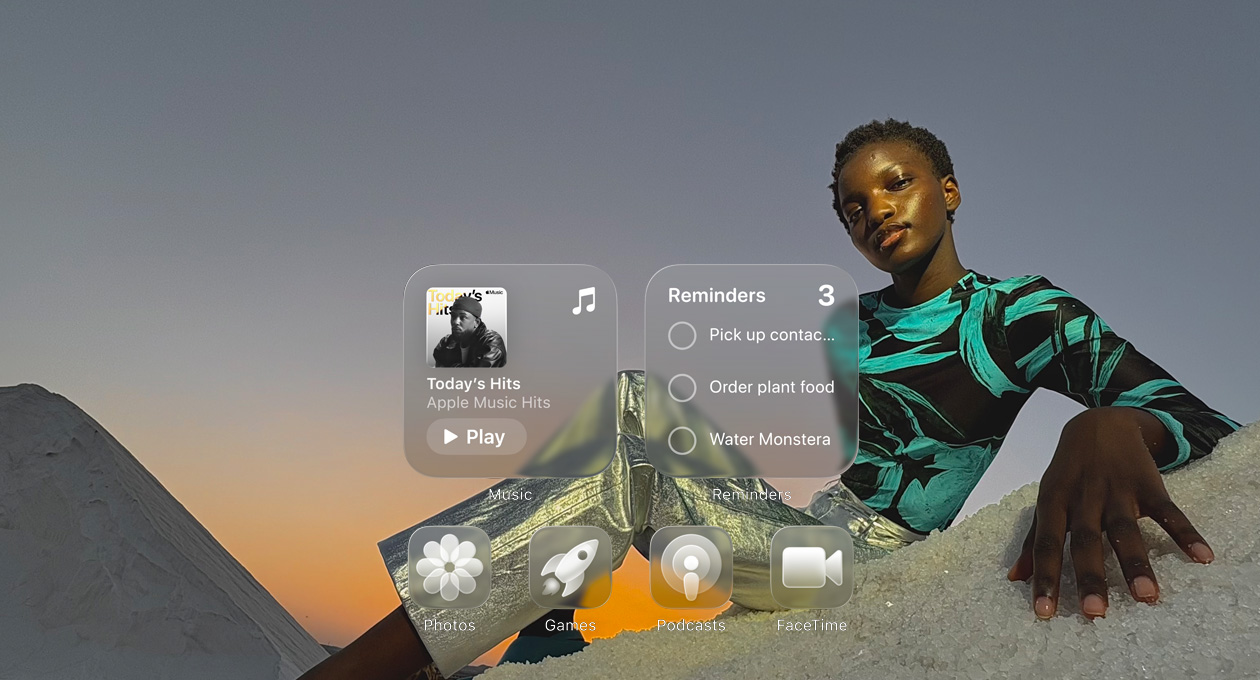 Liquid Glass display with clear app icons, like Apple Music, Reminders, Photos, Games, Podcasts and FaceTime, refracting against the wallpaper